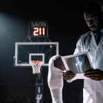Orthopedic doctor examines Wembanyama knee injury under spotlight with blurred hoop silhouette and Spurs logo.
