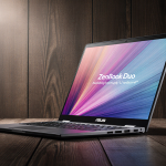 Laptop opening slightly reveals vibrant screen with warm natural light and dark wood grain background